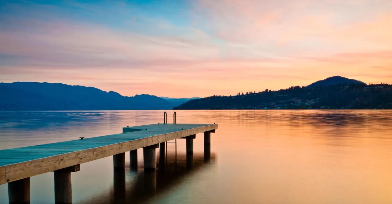 Wooden dock on a calm lake at sunset